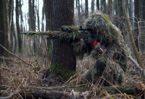 Militär prickskytt i kamouflage.