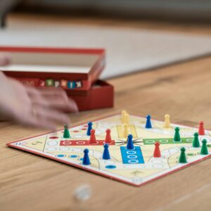 Bild på brädspelet fia med knuff och en hand som kastar en tärning.