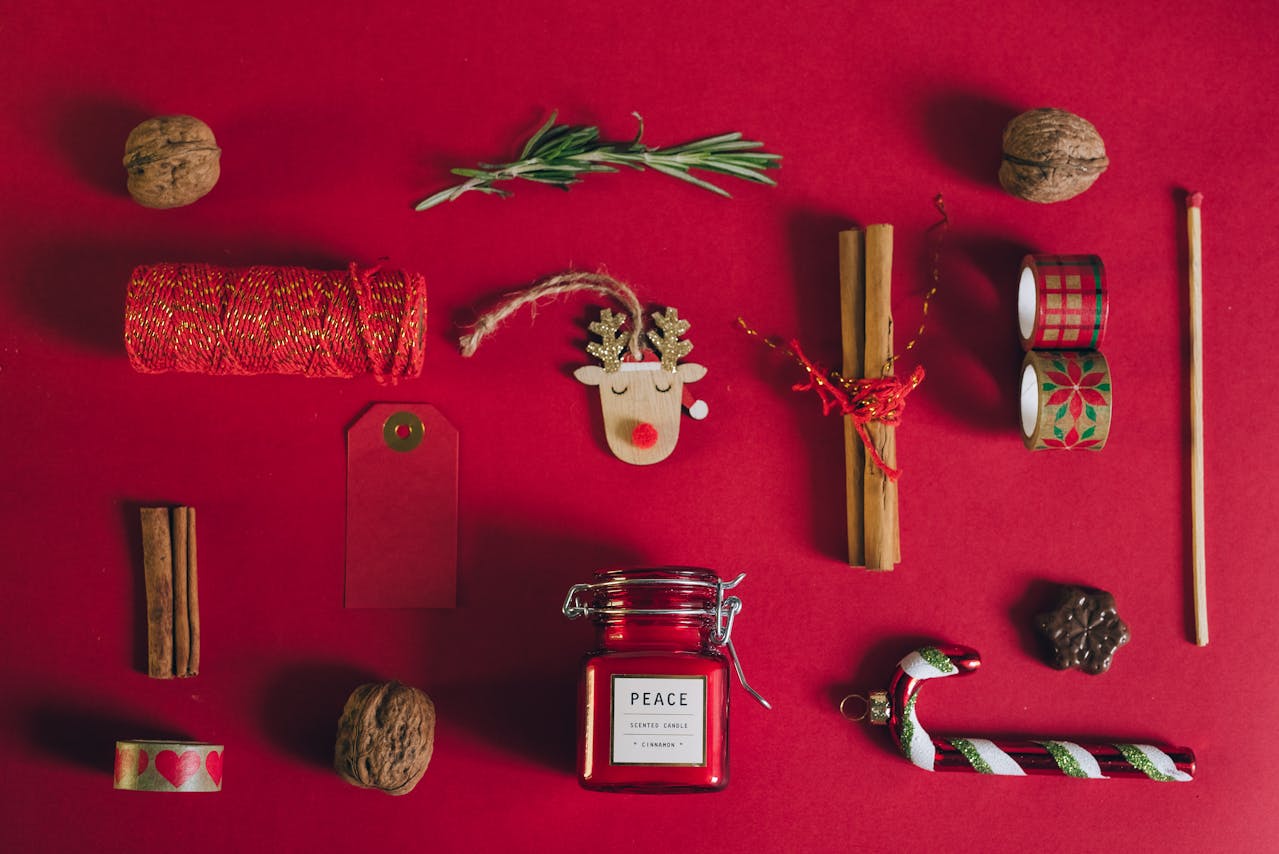 Julpynt och dekorationer ligger på en röd duk.