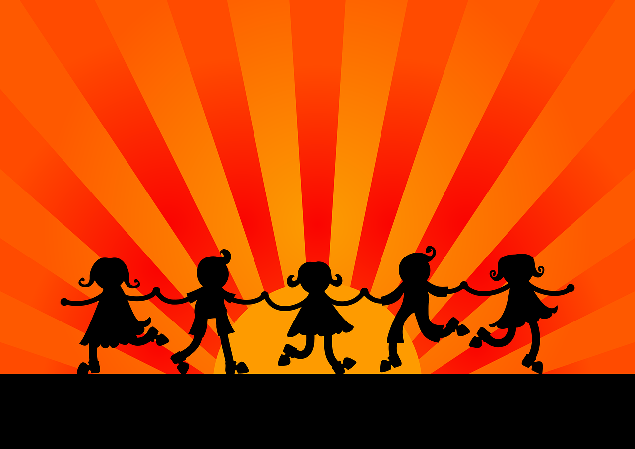 Bild på dansande barn vid solnedgången.