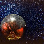 En stor discokula med glimrande ljus som reflekteras av discokulan.