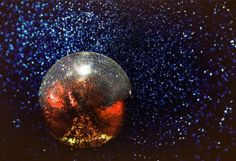 En stor discokula med glimrande ljus som reflekteras av discokulan.