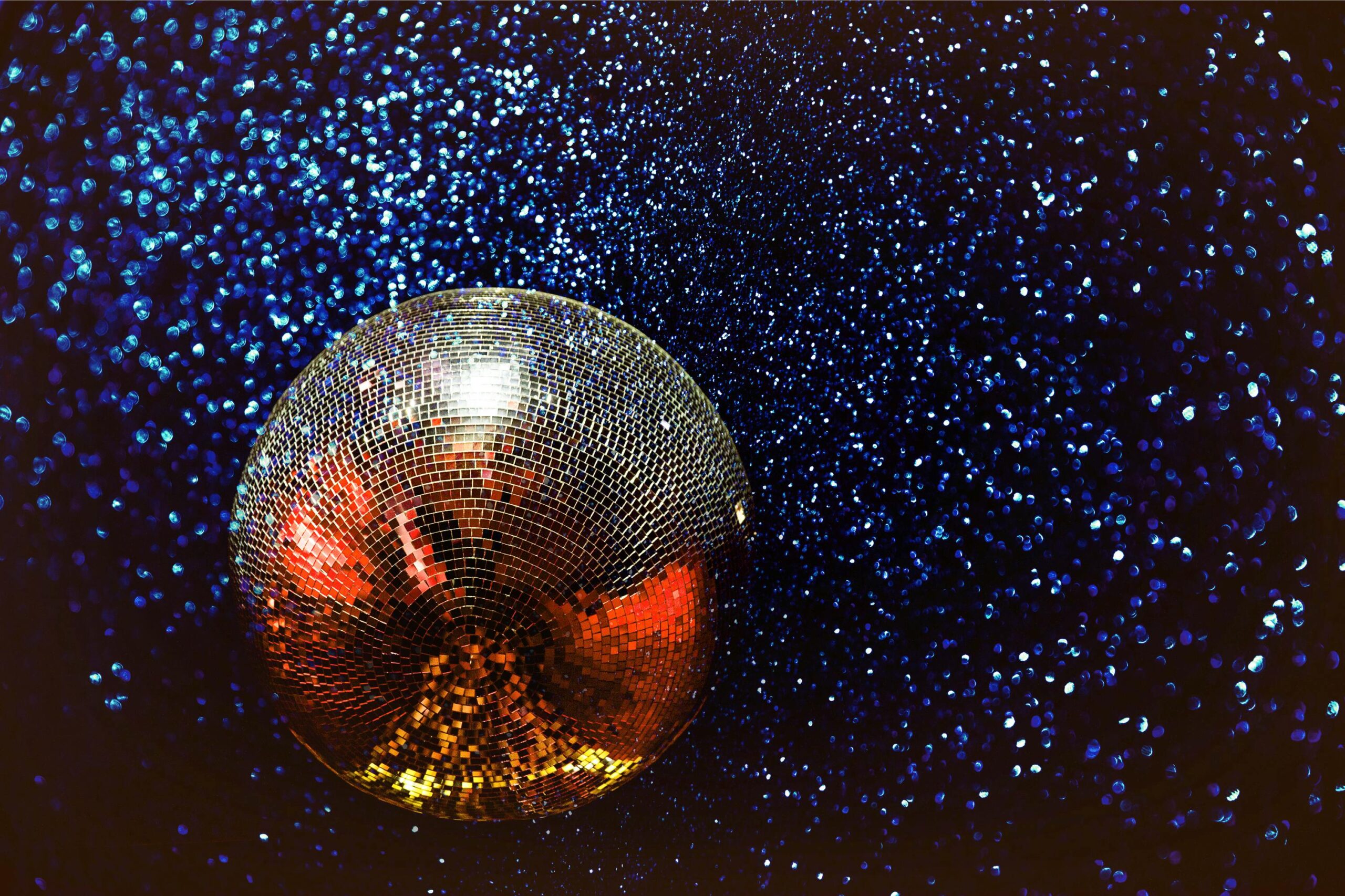 En stor discokula med glimrande ljus som reflekteras av discokulan.