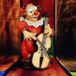 Bild på en clown-figur som spelar fiol.