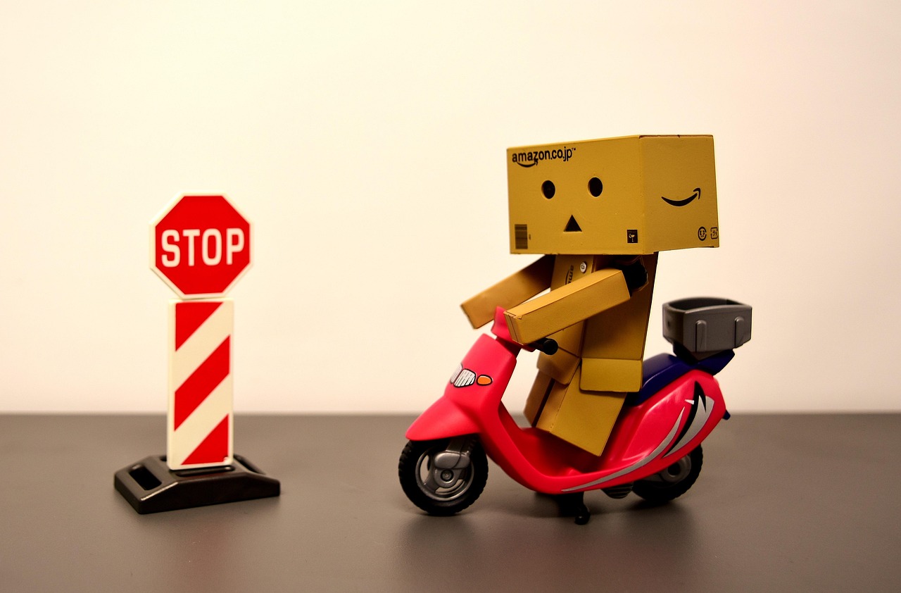 Bild på en danbo figur på en mini-motorcykel framför en stoppskylt.