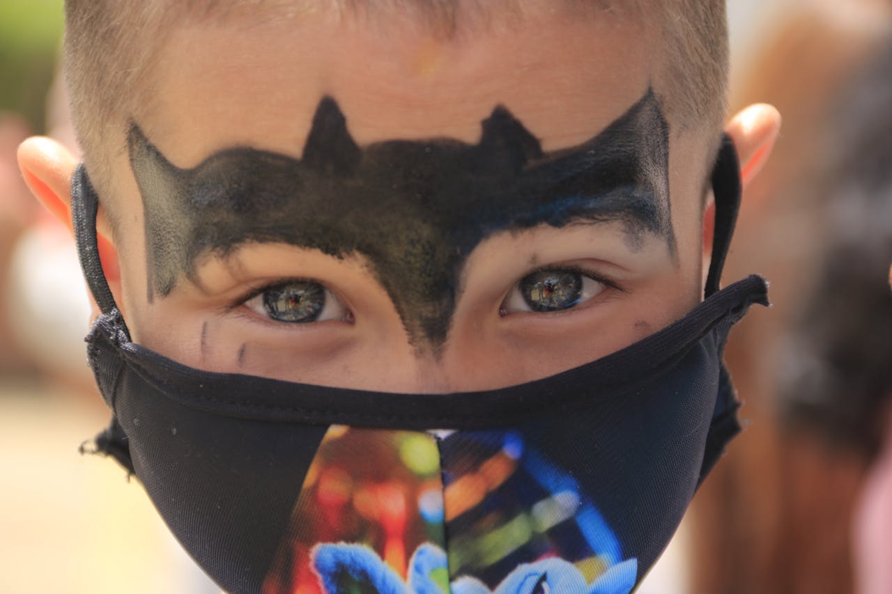 Pojke med ansiktsmålning och mask