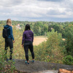 Bild på två personer som står ute i naturen.