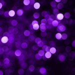 Den här bilden föreställer en lila bokeh-bakgrund med suddiga, glänsande cirklar.