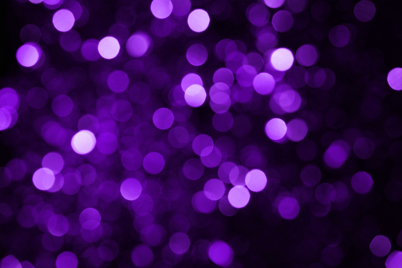 Den här bilden föreställer en lila bokeh-bakgrund med suddiga, glänsande cirklar.