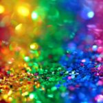 Bild på glitter i olika färger (rött, gult, grönt, blått, lila).