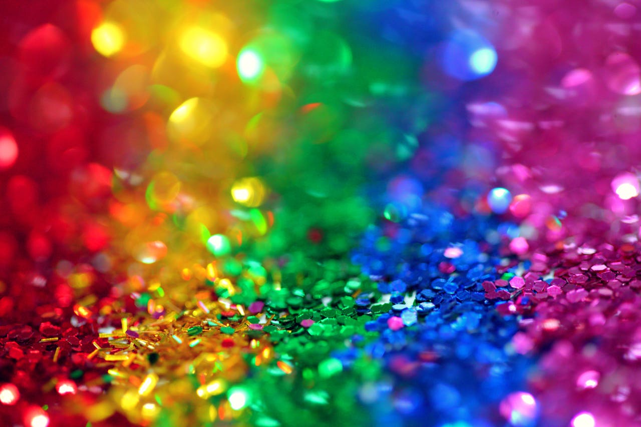 Bild på glitter i olika färger (rött, gult, grönt, blått, lila).