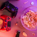 Bild på två playstation-kontroller på ett bord och en skål chips bredvid.