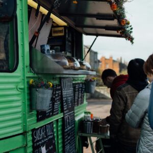 Personer som står i led för att handla mat från en foodtruck.