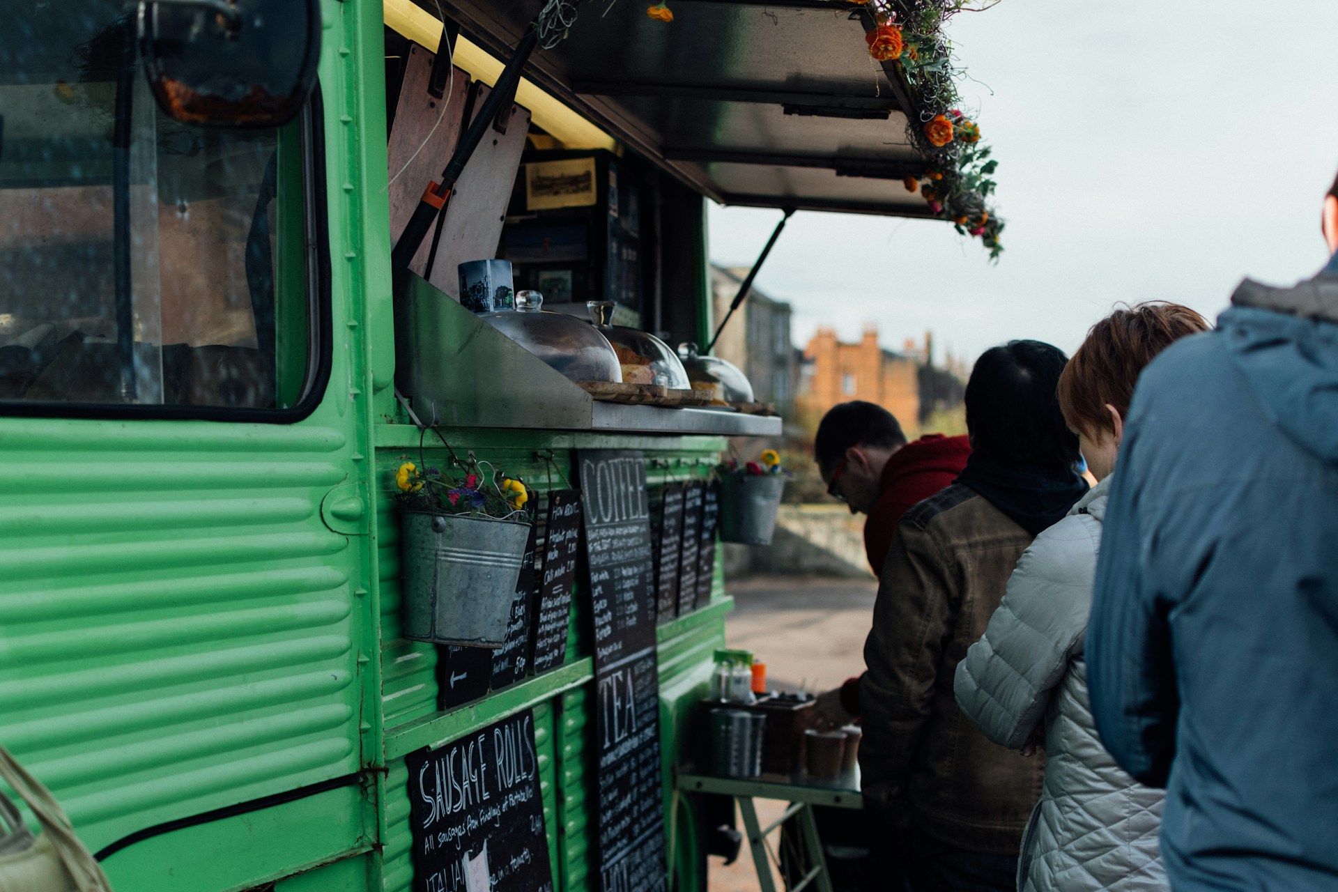 Personer som står i led för att handla mat från en foodtruck.