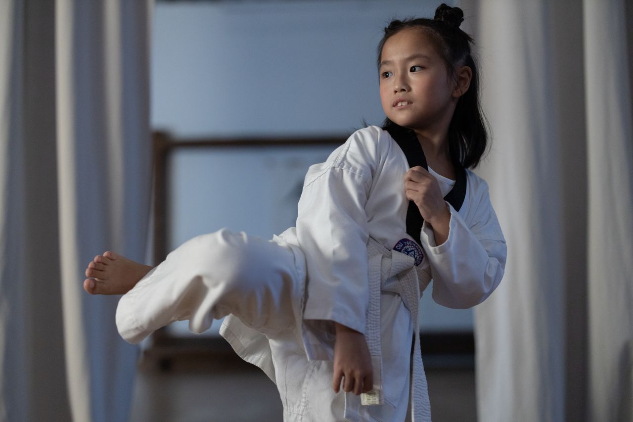 Flicka i 10-års åldern som genomför en Taekwondospark.