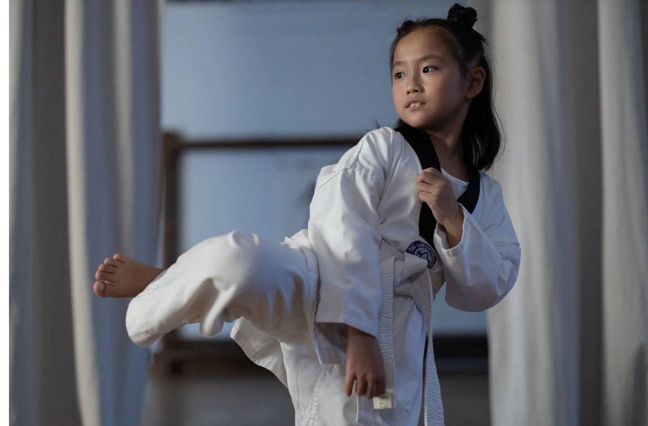 Flicka i 10-års åldern som utför Taekwondo