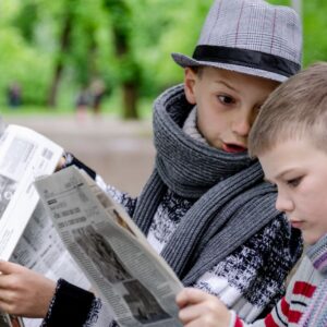 Två unga pojkar läser varsin tidning
