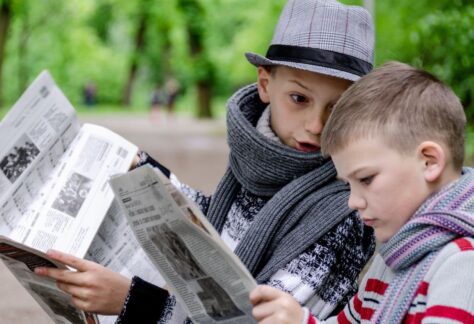 Två unga pojkar läser varsin tidning