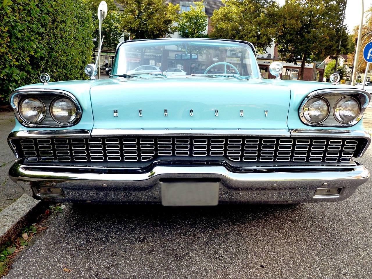 En äldre bilmodell (50-talet). Bilen står på en gata och är fotograferad framifrån.