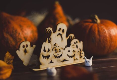 En festlig Halloween-inspirerad utsmyckning med träspöken och pumpor.