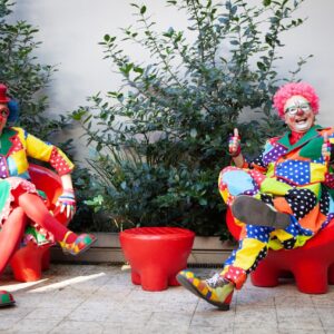 Bild på två clowner som sitter på varsinn stol.