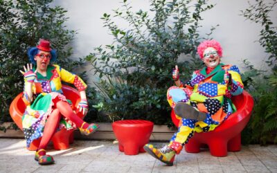 Bild på två clowner som sitter på varsinn stol.