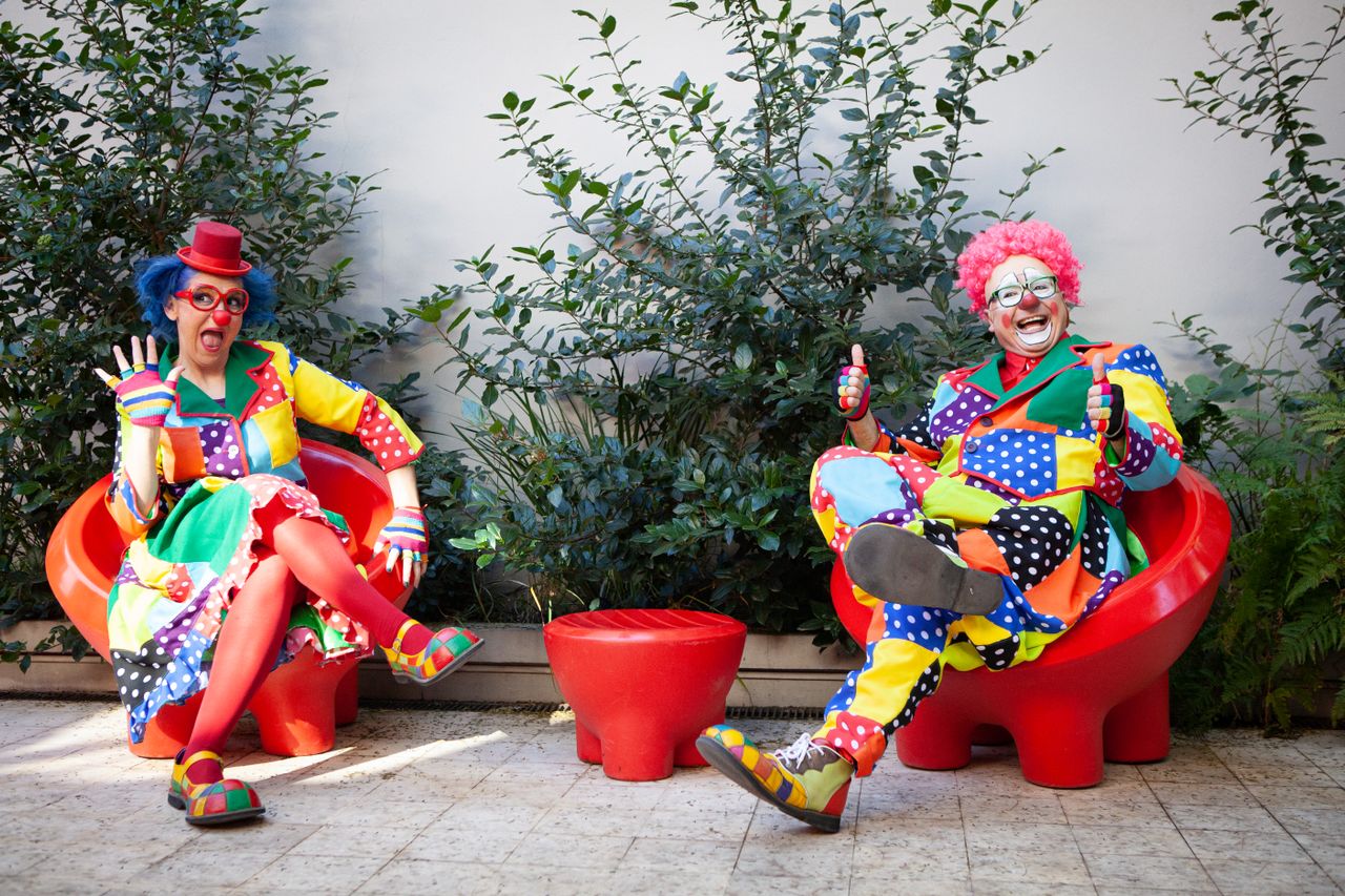 Bild på två clowner som sitter på varsinn stol.