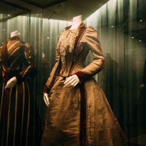 Eleganta vintageklänningar på modeller visade i en museiutställning.