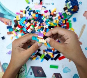 Bild på två händer som bygger med massor av lego.